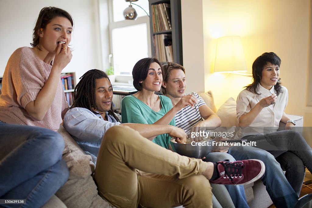 Friends watching a movie in living room