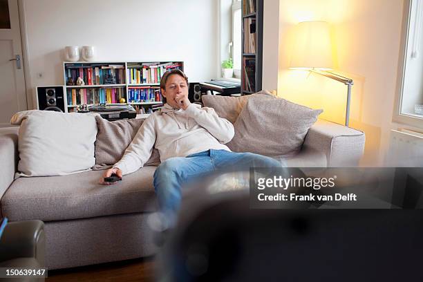 man yawning in front of television - fatigue full body stock-fotos und bilder