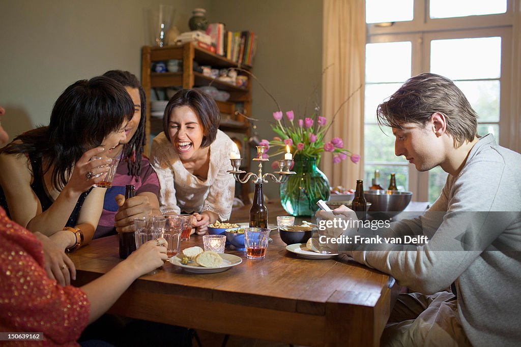 Friends laughing at dinner table