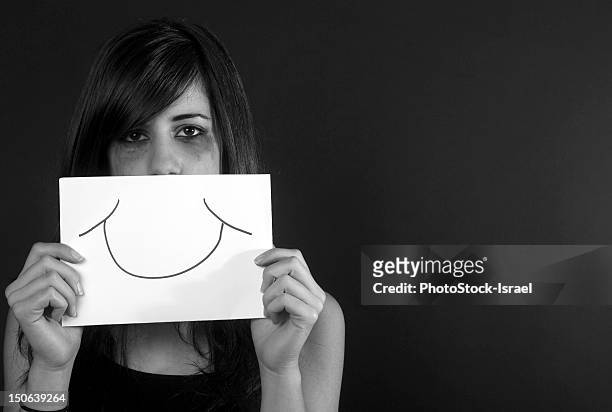 crying teenage girl holding fake smile - fake smile ストックフォトと画像