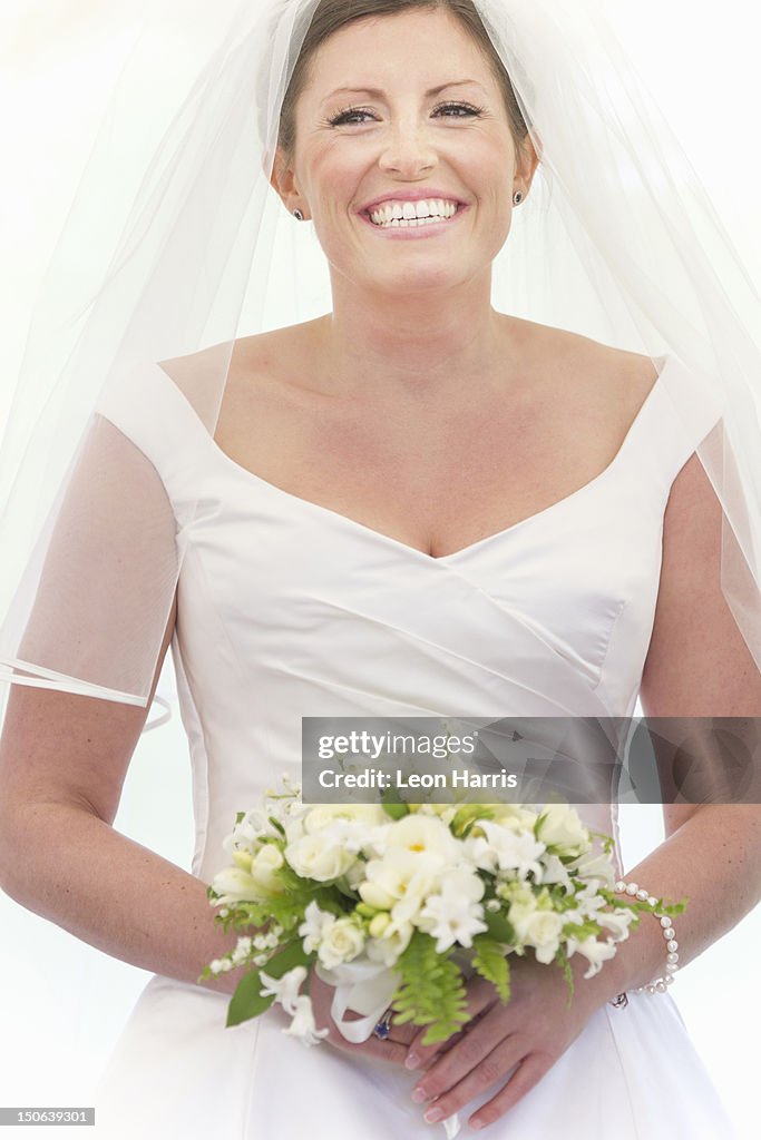 Smiling bride holding bouquet