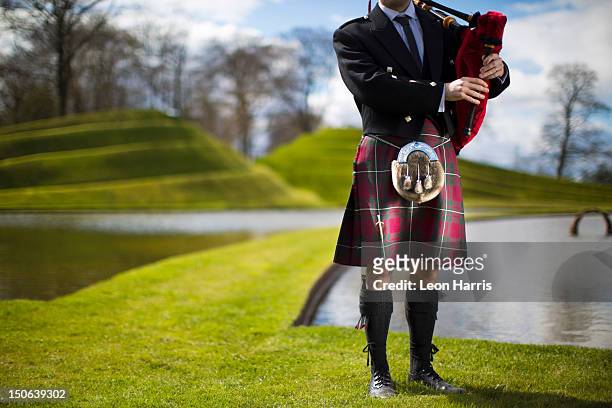 man in scottish kilt playing bagpipes - falda escocesa fotografías e imágenes de stock