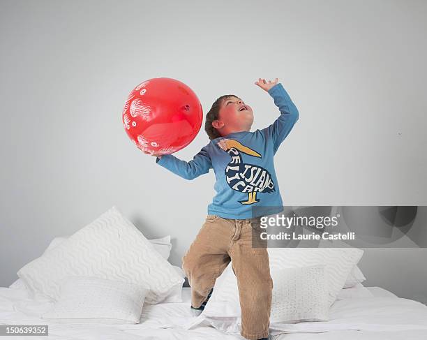 boy playing with balloon on bed - cundinamarca stockfoto's en -beelden