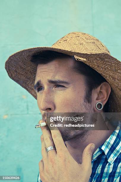 close up of man smoking cigarette - ornement auriculaire photos et images de collection