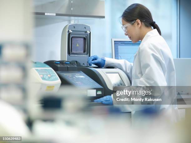 scientist conducting the process of polymerase chain reaction (pcr) to amplify dna by using a thermocycler to create samples - genetisch onderzoek stockfoto's en -beelden