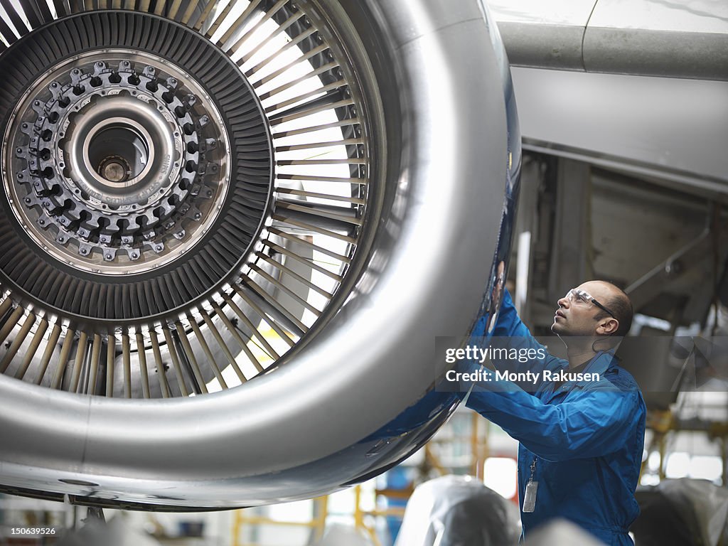 Aircraft engineer working on 737 jet engine in airport