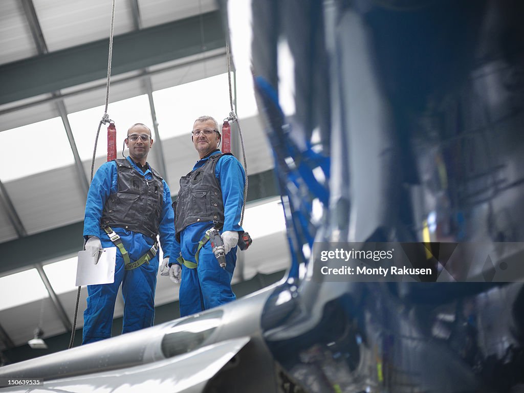 Aircraft engineers working on wing of 737 jet airplane in airport