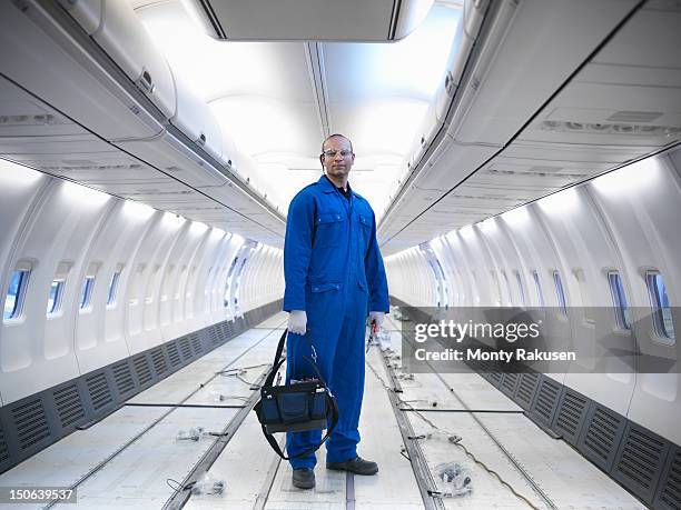 aircraft engineer working on interior of 737 jet airplane - overall stockfoto's en -beelden