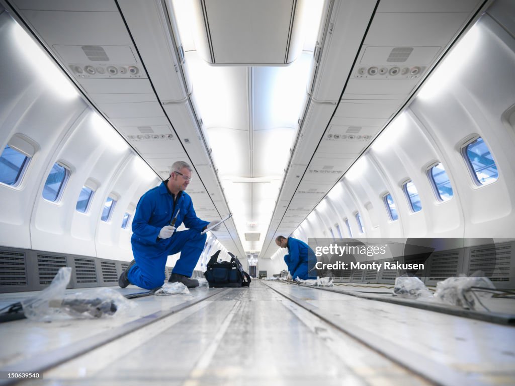 Aircraft engineers working on interior of 737 jet airplane