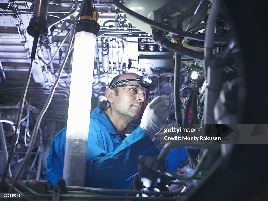 Aircraft engineer working on undercarriage area of 737 jet plane