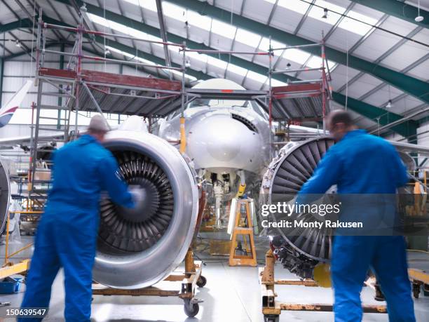 aircraft engineers inspecting jet engines of jet airplane - vliegtuigmonteur stockfoto's en -beelden