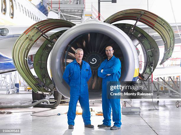 portrait of aircraft engineers in front of 737 engine in hangar - overall stockfoto's en -beelden