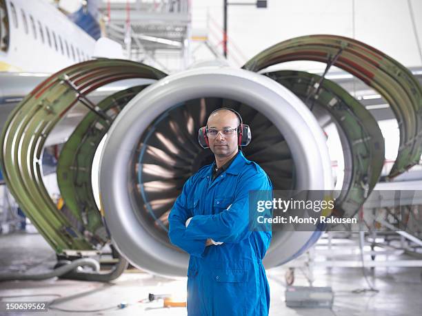 portrait of aircraft engineer in front of 737 engine in hangar - monty rakusen portrait stock pictures, royalty-free photos & images