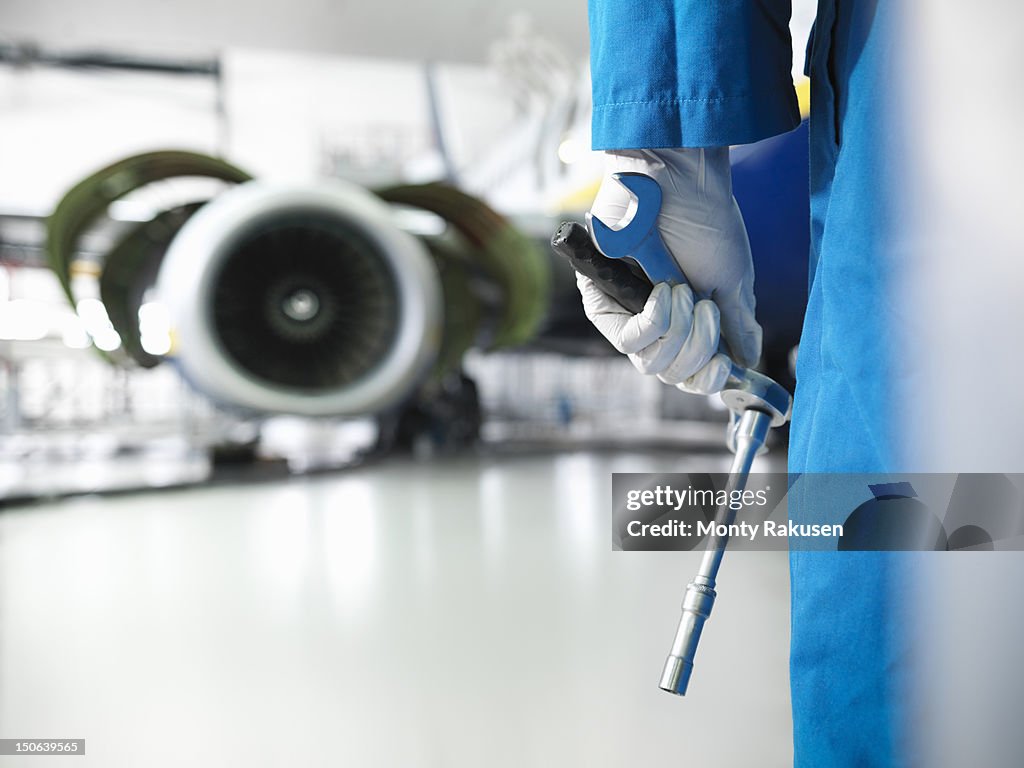 Close up of engineer holding tools in aircraft hangar