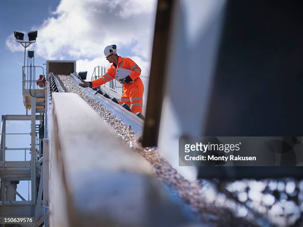 worker standing by stone screening and crushing machine in quarry - mining natural resources stock pictures, royalty-free photos & images