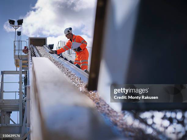 worker standing by stone screening and crushing machine in quarry - exploração mineira imagens e fotografias de stock