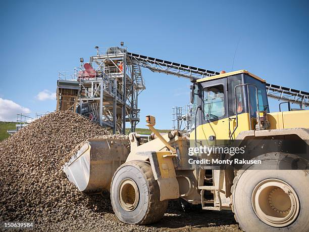 digger picking up crushed stones from pile in quarry - gravel quarry stock pictures, royalty-free photos & images