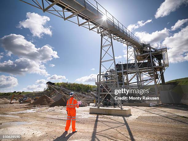 workman standing next to stone screening and crushing machine in quarry - screening of england is mine stock pictures, royalty-free photos & images
