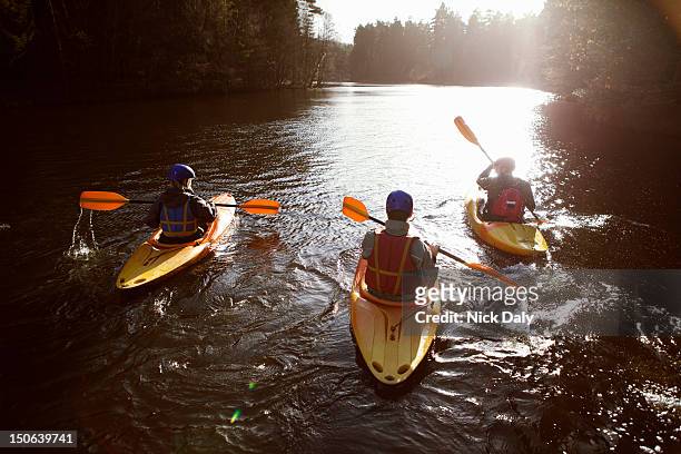 kayakers rowing together on still lake - kayak 個照片及圖片檔
