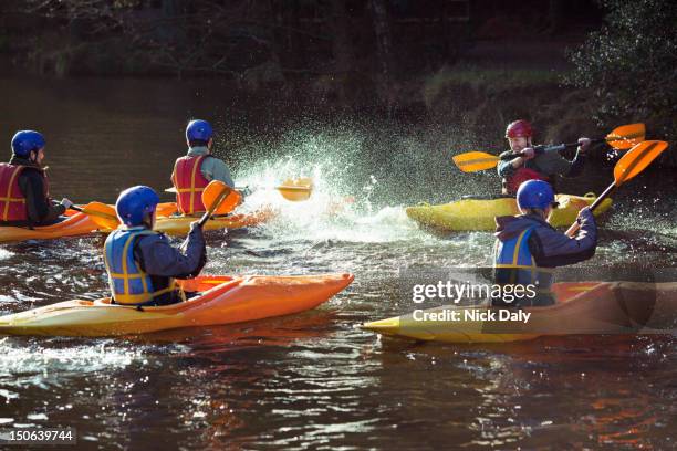 kayakers rowing together on still lake - water sports stock pictures, royalty-free photos & images