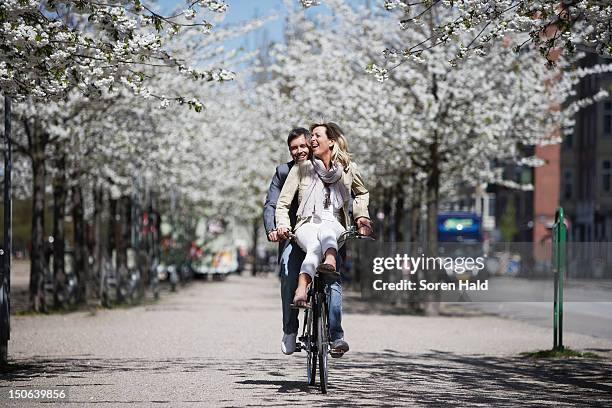 男性と女性の自転車に乗る - blossom trees ストックフォトと画像