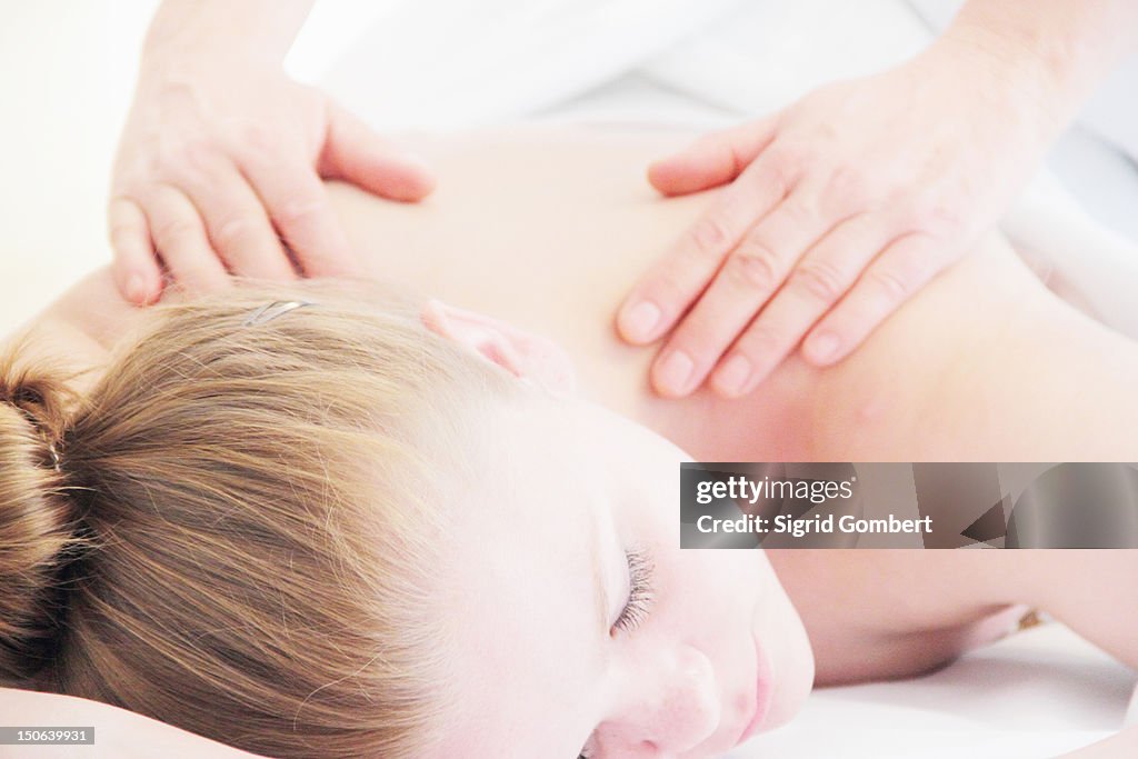 Woman having back massage in spa