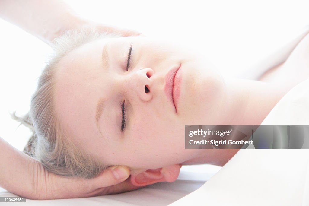 Woman having scalp massage in spa