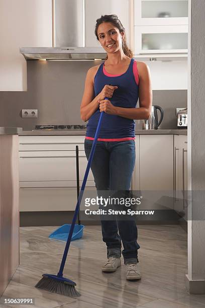 smiling woman cleaning kitchen floor - holding broom stock pictures, royalty-free photos & images