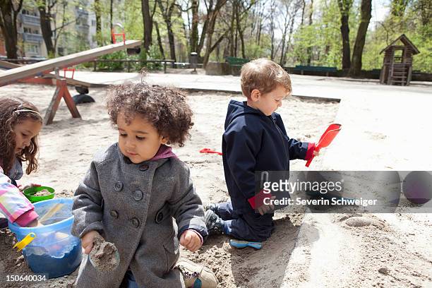 children playing with sand in playground - 2 kid in a sandbox fotografías e imágenes de stock