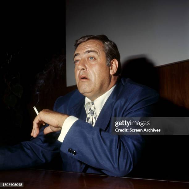 Canadian actor Raymond Burr smoking a cigarette, circa 1960.