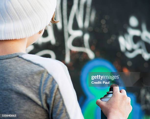 teenage boy holding spray can in front of graffiti wall - tag 14 photos et images de collection