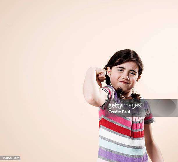 girl flexing her muscles - children only stock-fotos und bilder