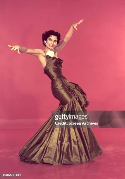 American actress and dancer Cyd Charisse in a ballgown, circa 1957.