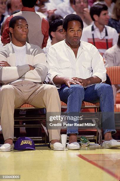 Finals: Los Angeles Raiders Marcus Allen and Hall of Famer O.J. Simpson sitting courtside during Los Angeles Lakers vs Boston Celtics at The Forum....