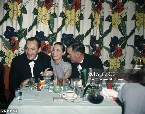 American actress and singer Dorothy Lamour laughing with other diners at a Hollywood restaurant, circa 1945.