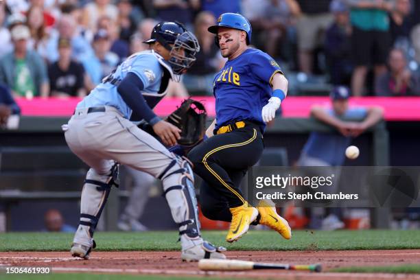 Jarred Kelenic of the Seattle Mariners scores a run past Jose Siri of the Tampa Bay Rays during the second inning at T-Mobile Park on June 30, 2023...