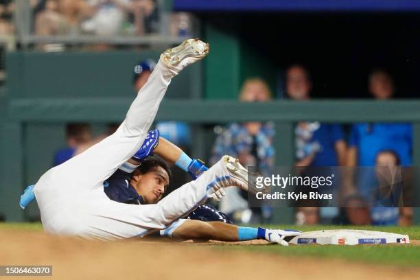 Nicky Lopez of the Kansas City Royals avoids the tag from Caleb Ferguson of the Los Angeles Dodgers at first base during the seventh inning at...