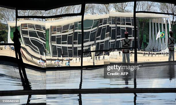 The image of the Brazilian Supreme Court building, where the trial known as 'mensalao' is being held, is seen reflected on a mirror wall inside the...