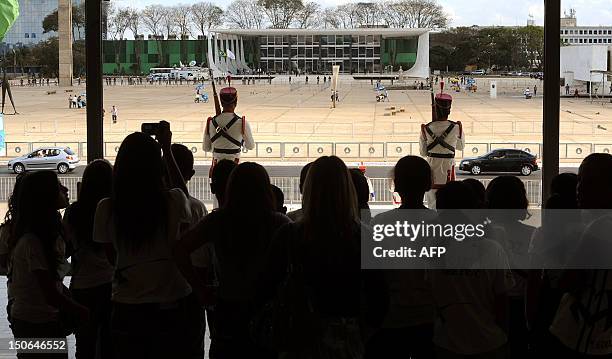 Tourists and children visiting the Planalto Palace look at the Square of the Three Powers, with the Supreme Court in the background, where the trial...