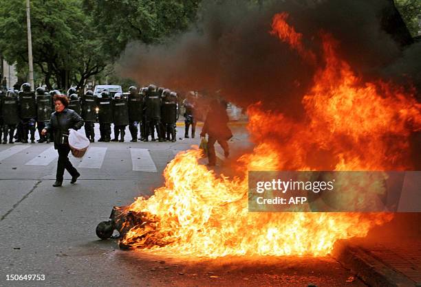 Argentinian riot police remain behind a fire during clashes with demonstrators protesting against a pension system reform in Cordoba, Argentina on...