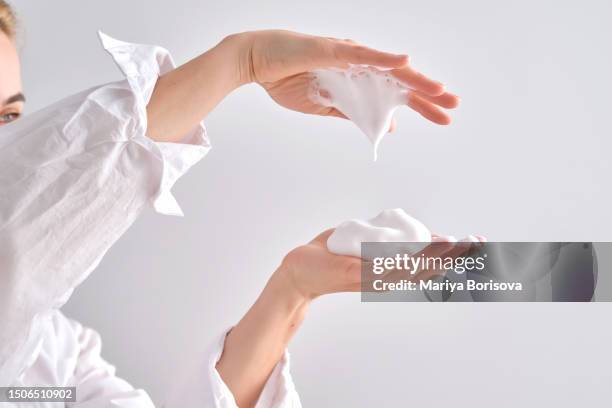 air foam for washing in female hands. - foam material stockfoto's en -beelden