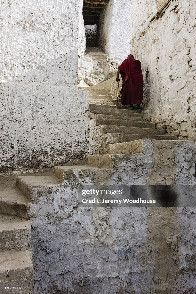 A monk climbing stairs at Thiksey Monastery