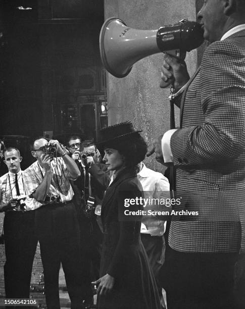 Director George Cukor on bullhorn as Audrey Hepburn is photographed during the filming of 'My Fair Lady' at Burbank, California, 1963.