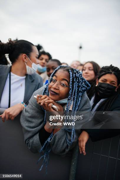 Crowds wait outside a venue at Paris Fashion Week