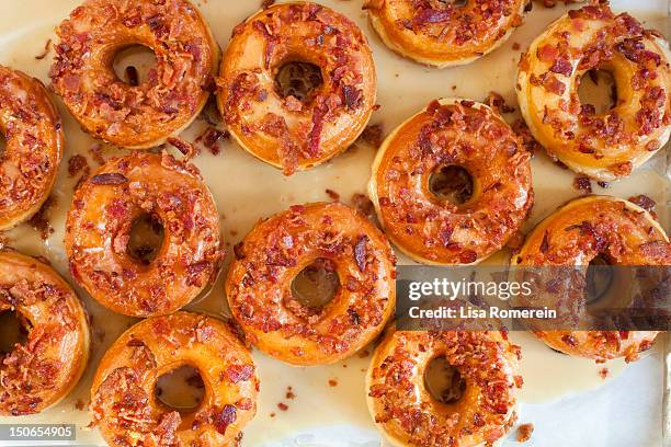 multiple maple glazed bacon donuts - glazed donut stock pictures, royalty-free photos & images