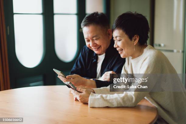 asian couple using smartphone at home - chinese people stock pictures, royalty-free photos & images
