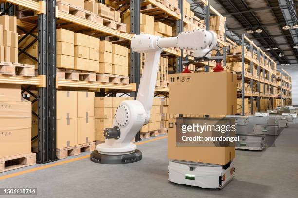 intelligentes lager mit roboterarm, der kartons auf fts legt - smart factory stock-fotos und bilder