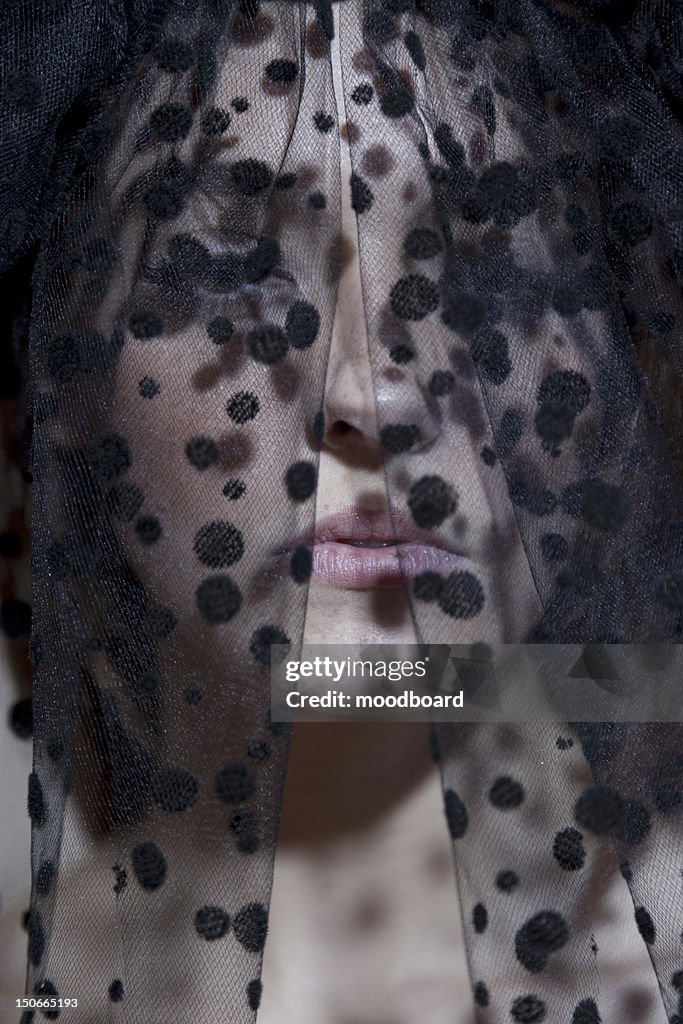 Close-up of a young woman in black veil looking away