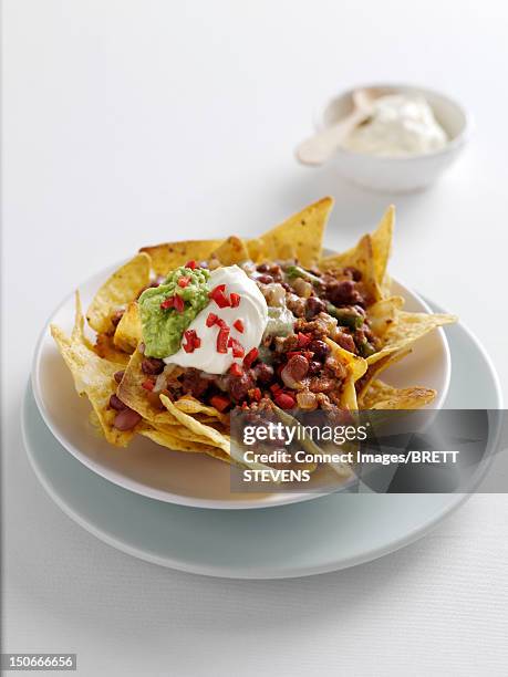 plate of nachos with sour cream - sour cream stock pictures, royalty-free photos & images