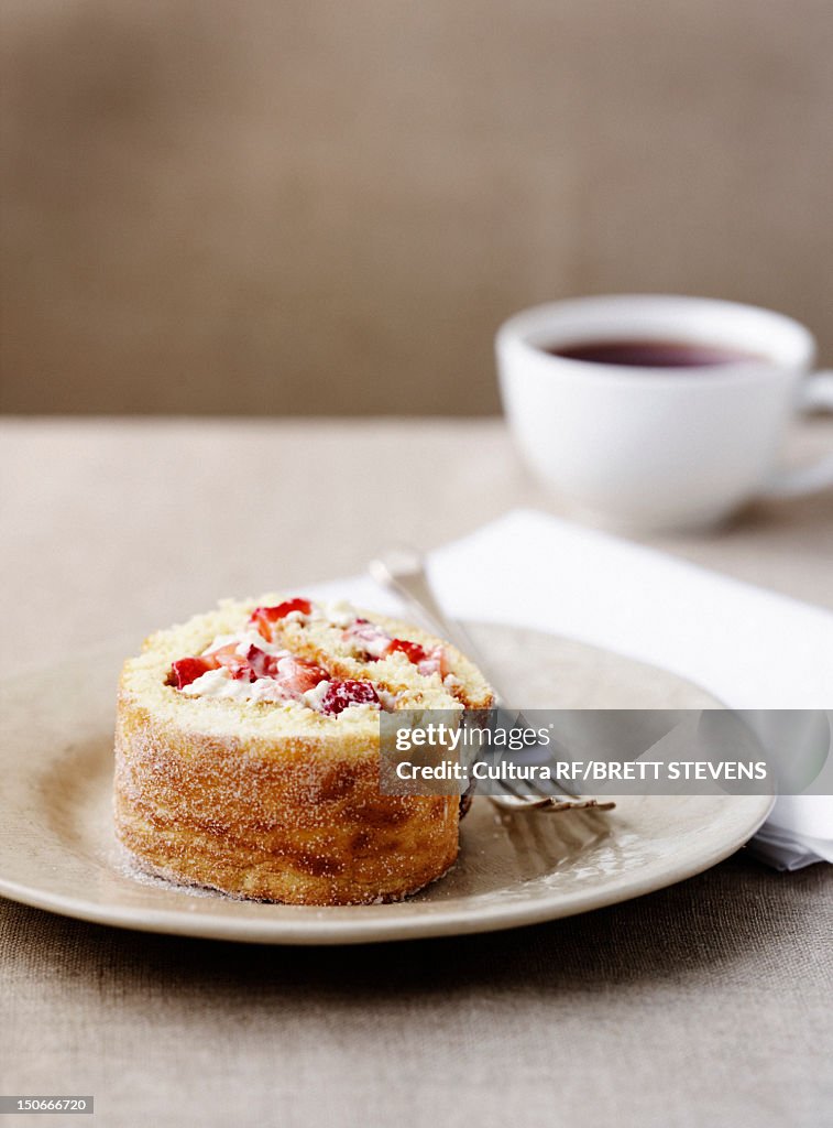 Plate of fruit swiss roll with coffee